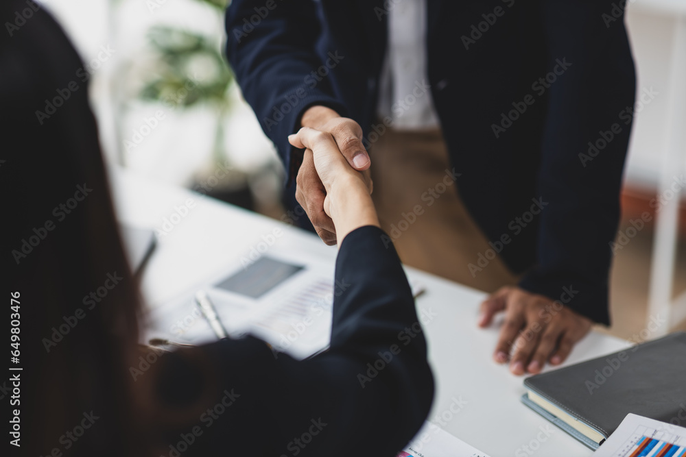 Business partners and colleagues shaking hands at work cooperation. Job applicant shaking hands with executives in office room at job interview.