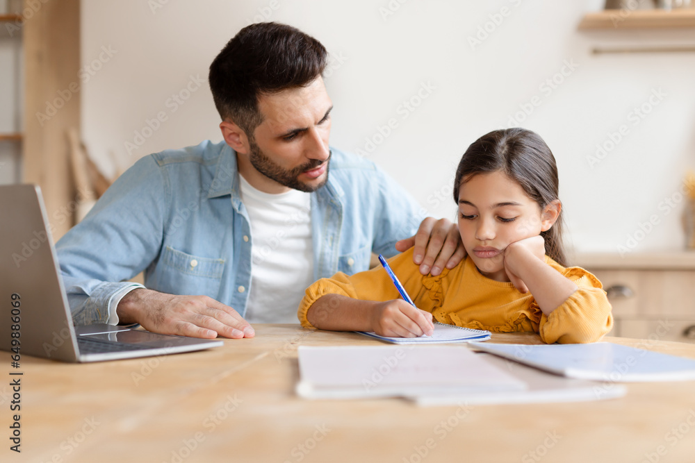 Dad helping frustrated daughter with homework using laptop at home