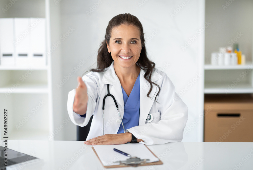 Portrait of friendly attractive mature woman doctor in clinic