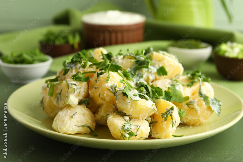 Plate of tasty Potato Salad with greens on table, closeup