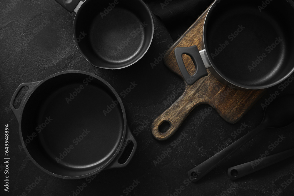 Set of cooking pots on dark background