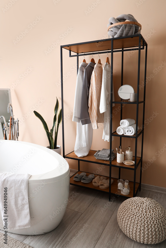 Interior of bathroom with shelving unit and bathtub