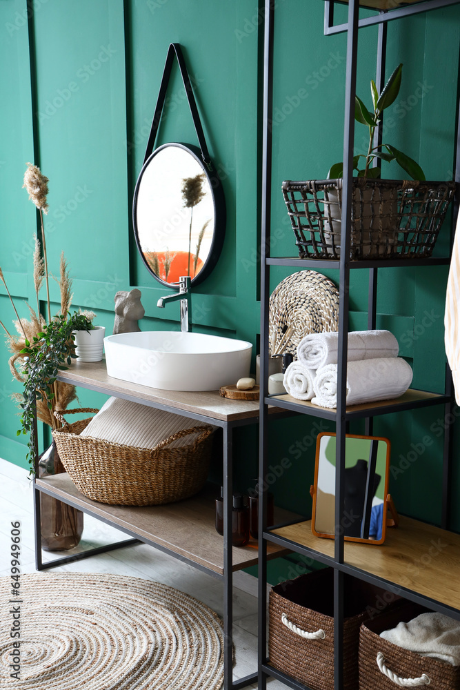 Interior of bathroom with sink, table and shelving unit