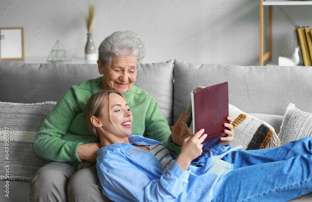 Young woman and her grandmother with photo album at home