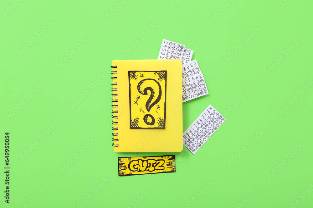 Notebook with quiz form and card on green background