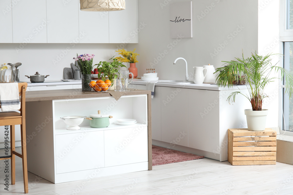 Interior of light kitchen with stylish island table