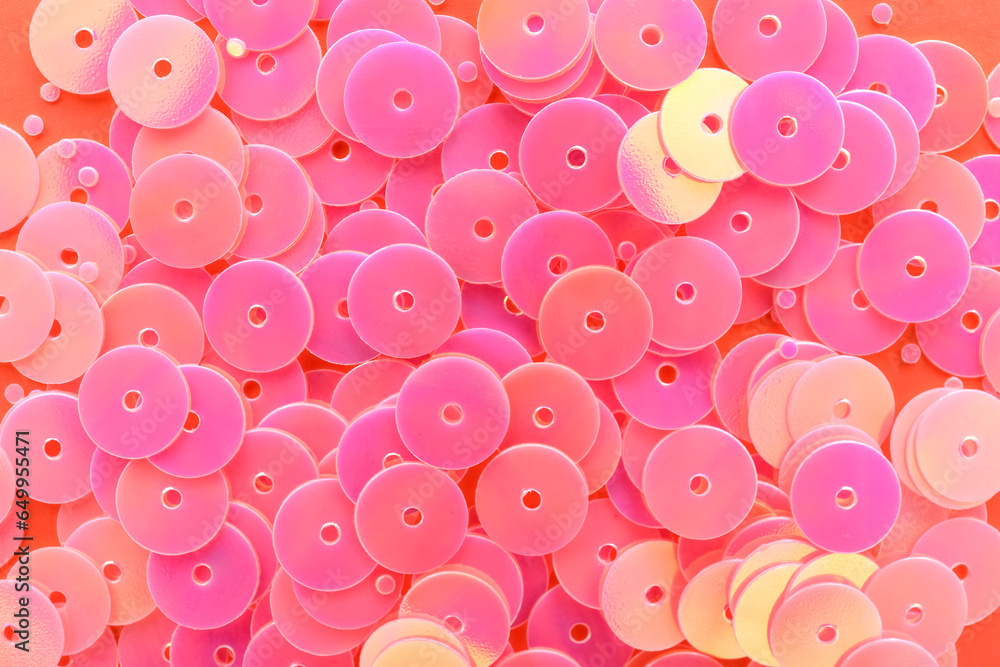 Heap of pink sequins on coral background