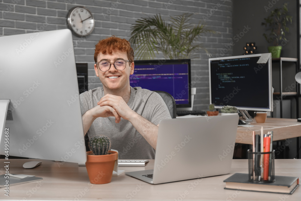 Male programmer working with computer at table in office