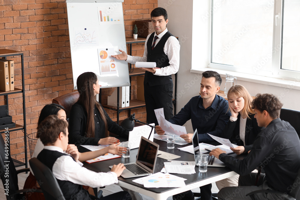 Male business consultant giving presentation to his colleagues in office