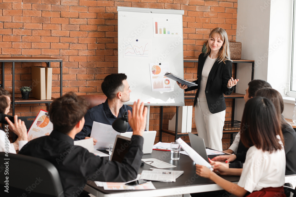 Female business consultant giving presentation to her colleagues in office