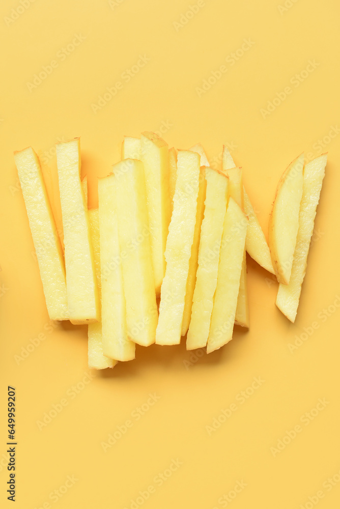 Pieces of cut potato on yellow background