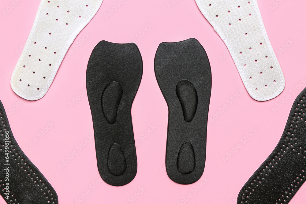 Composition with different orthopedic insoles on pink background, closeup