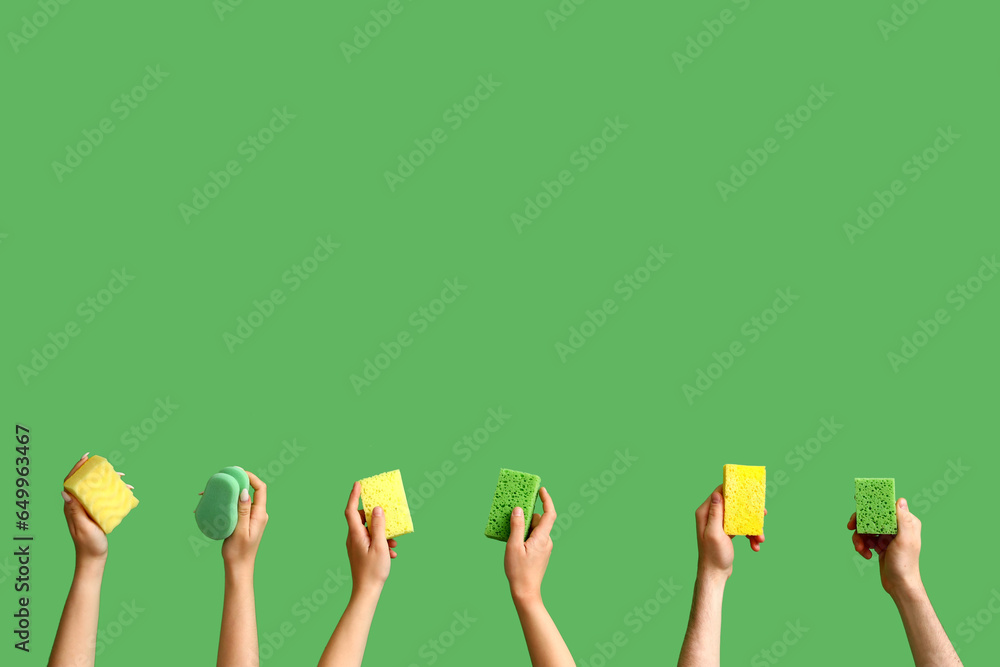 Women with cleaning sponges on green background