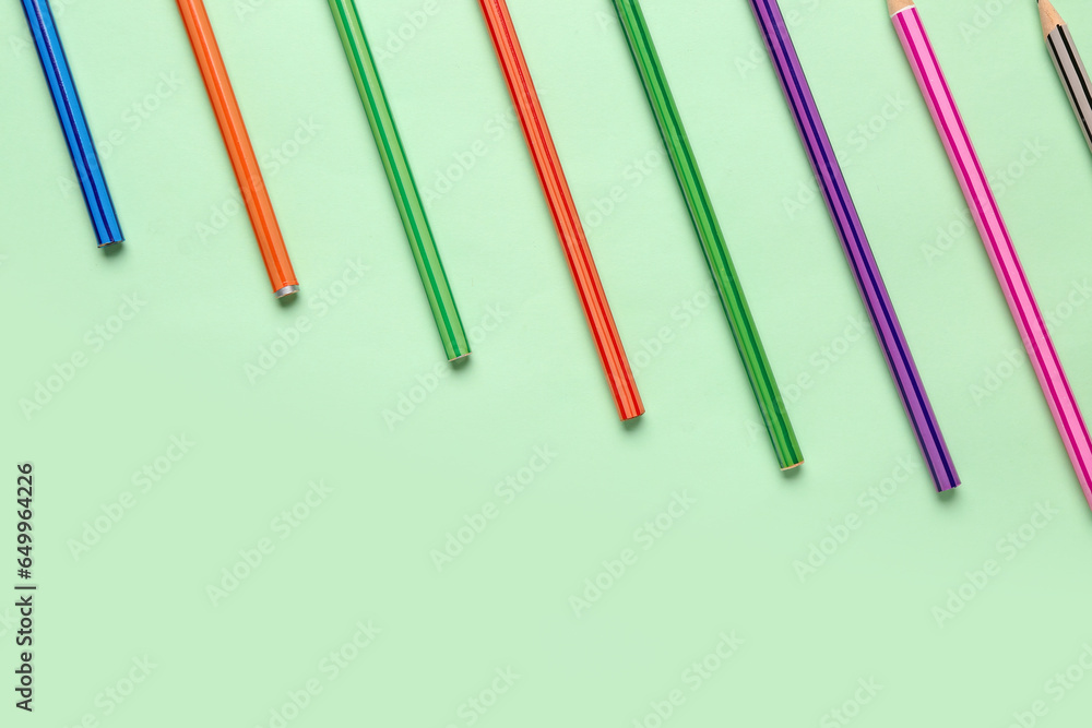 Group of colorful pencils on light green background