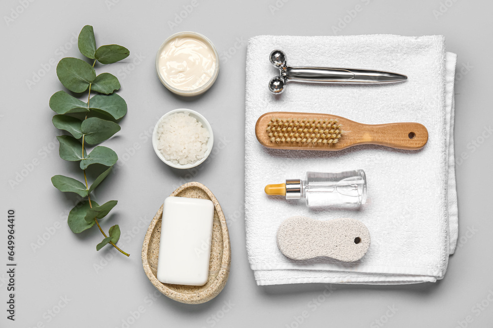 Composition with different bath supplies and eucalyptus branch on grey background