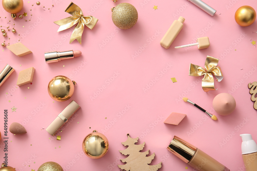 Frame made of beautiful golden Christmas decorations and makeup products on pink background