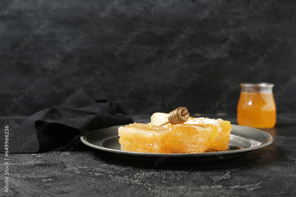 Plate with fresh honeycombs on dark background