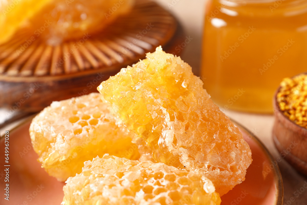 Plate with sweet honeycombs on table, closeup