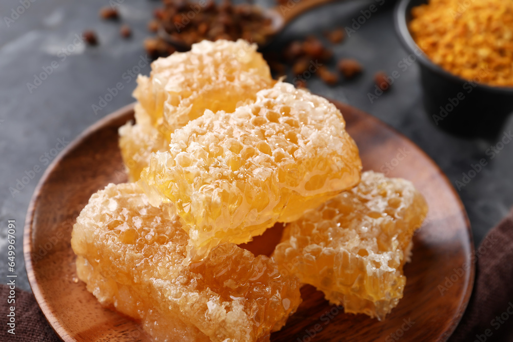 Plate with sweet honeycombs on black background