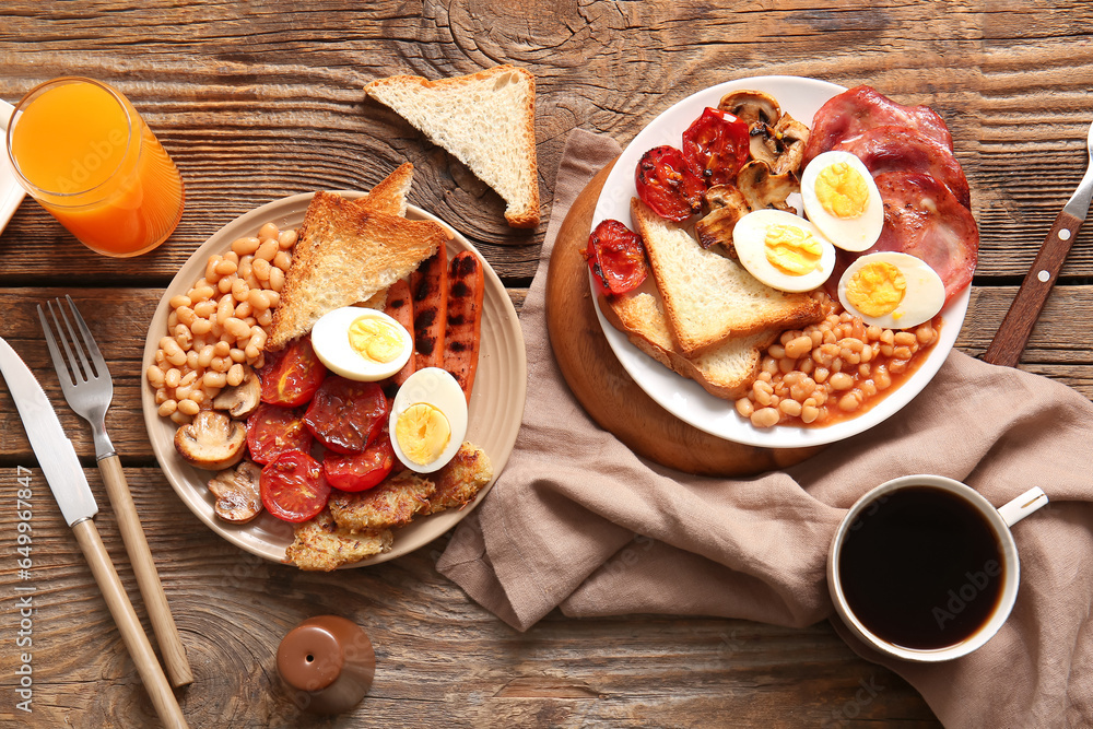 Plates of tasty English breakfast with juice and coffee on wooden background