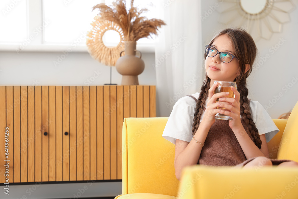 Little girl with glass of juice at home