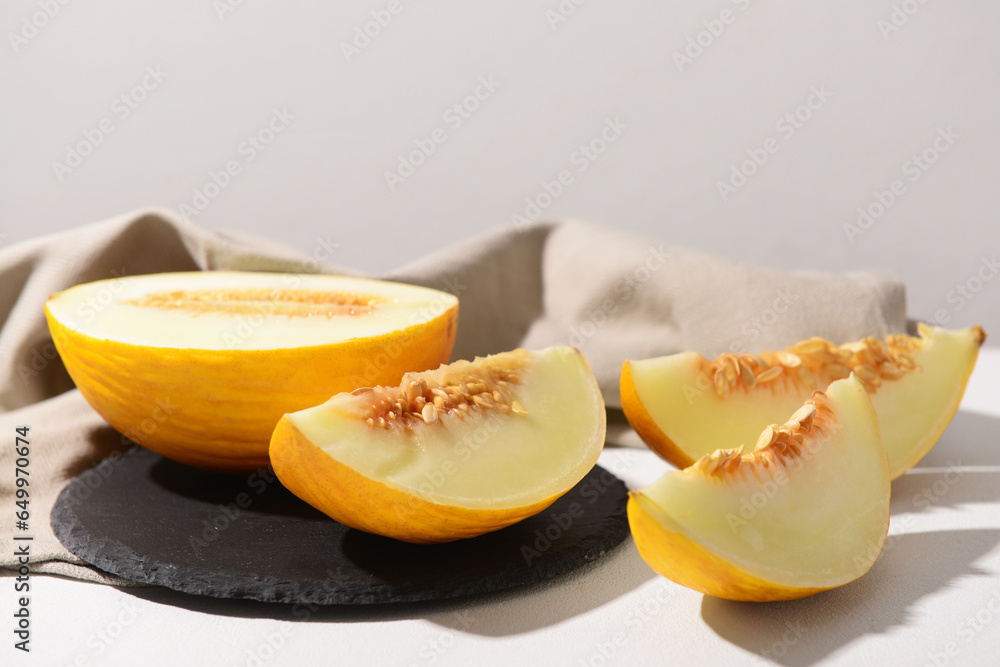 Board with sweet melon on white background