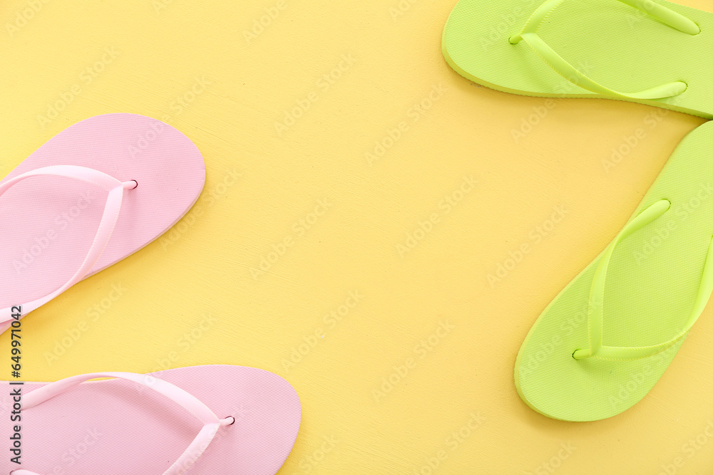 Frame made of colorful pairs of flip flops on yellow background