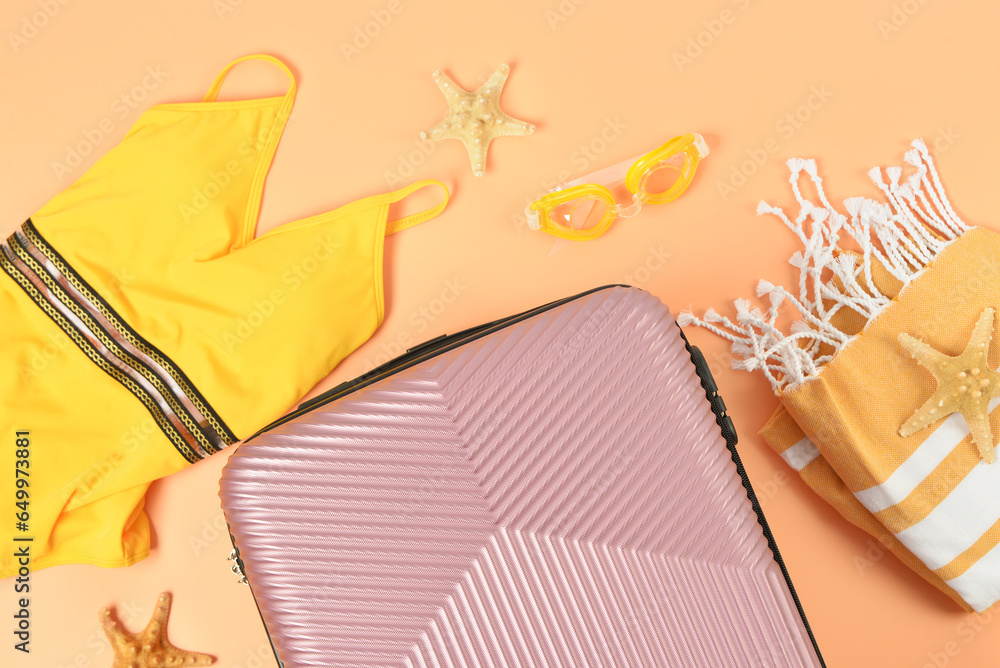 Composition with suitcase and beach accessories on color background, closeup