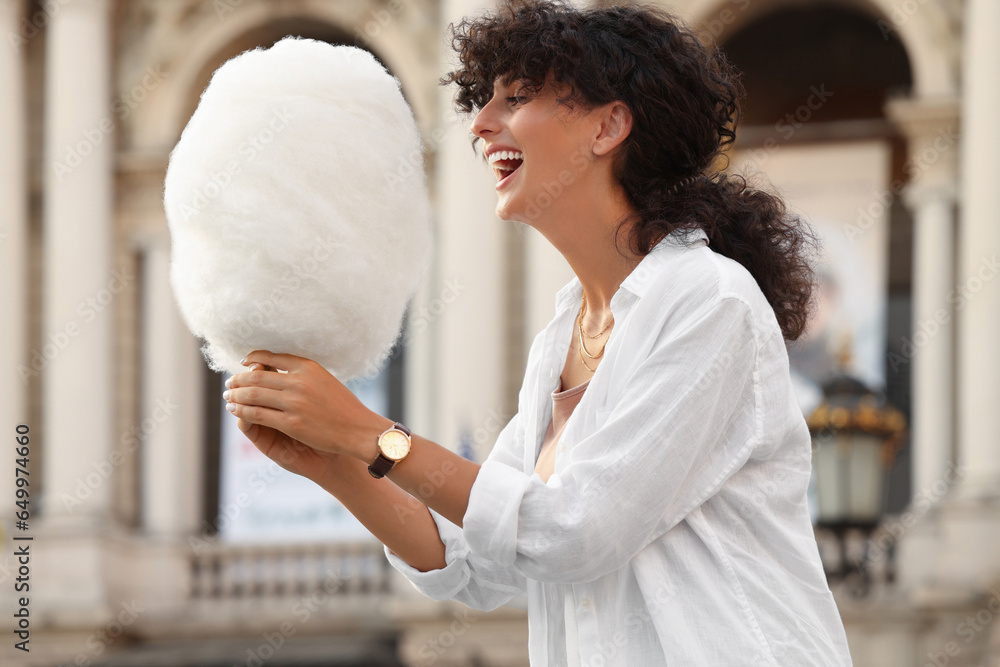 Beautiful woman with cotton candy on city street