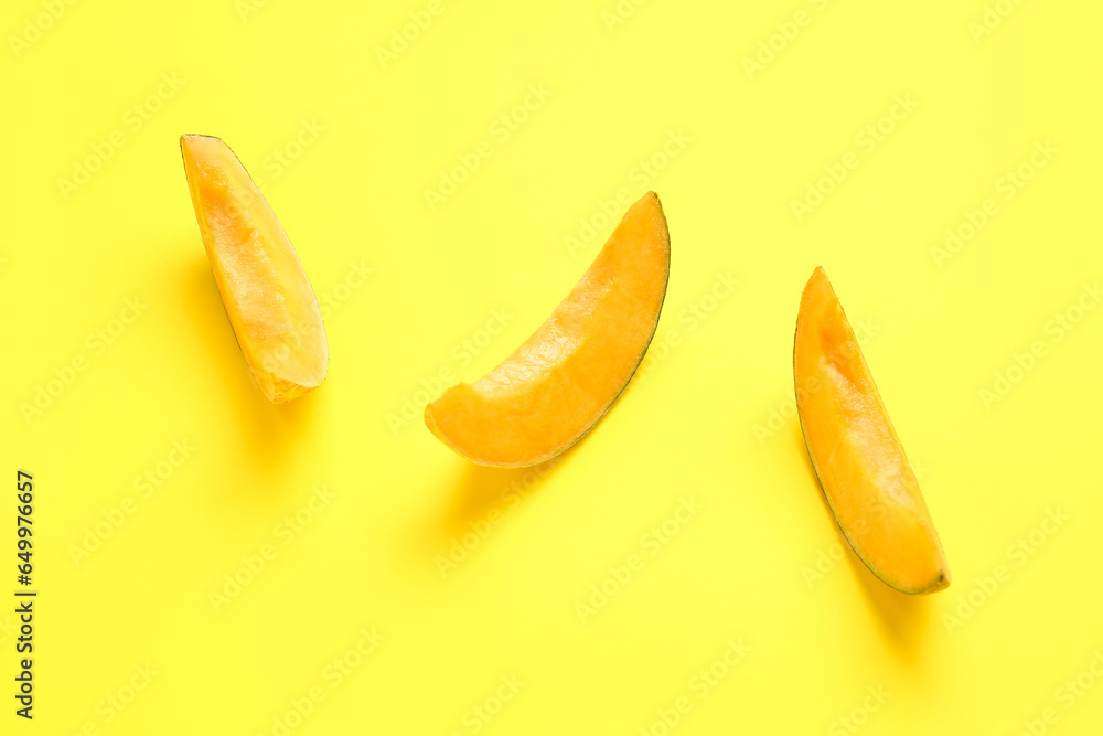 Pieces of sweet melon on yellow background