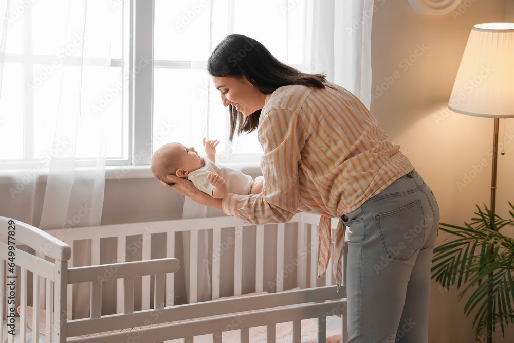 Young woman with her little baby in bedroom