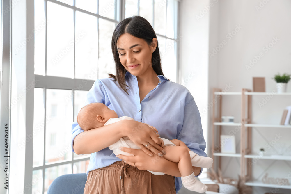 Young woman with her sleeping baby at home