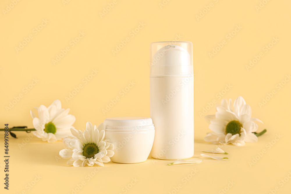 Cosmetic products and chamomile flowers on color background