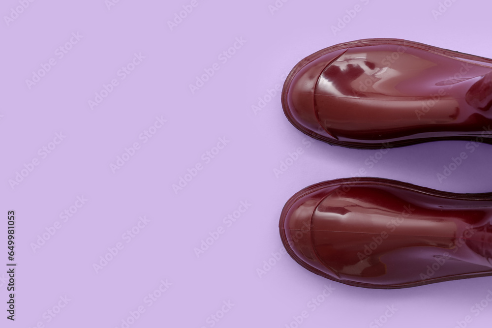 Red gumboots on lilac background