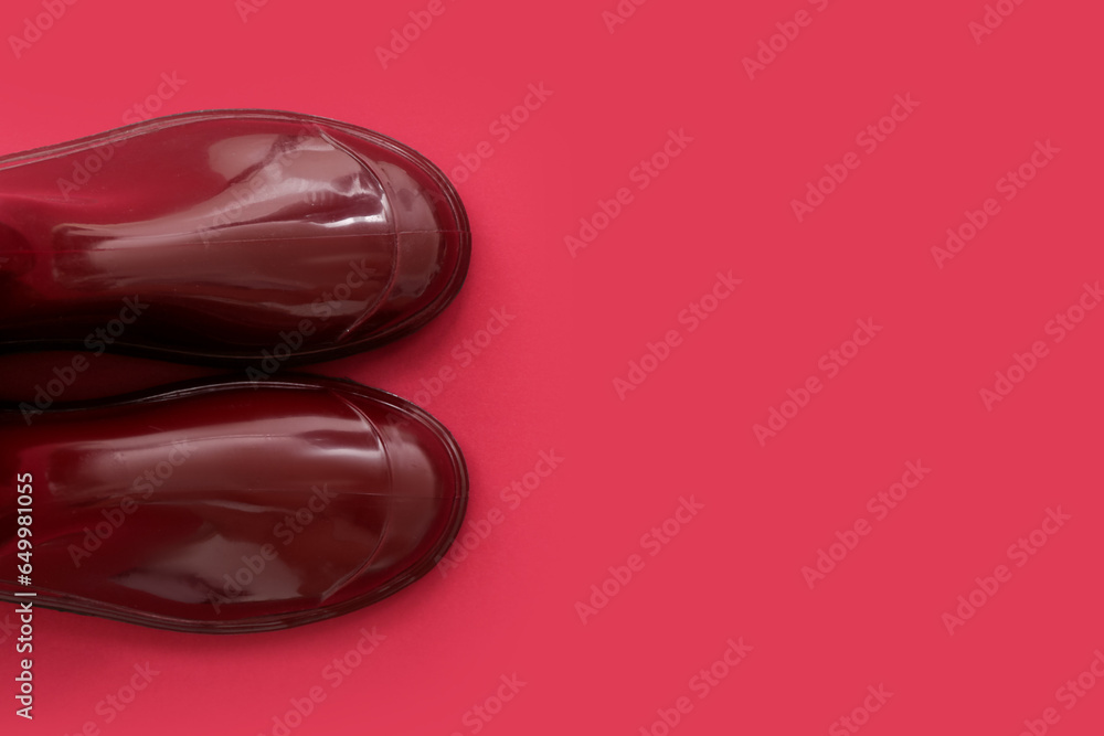 Red gumboots on color background