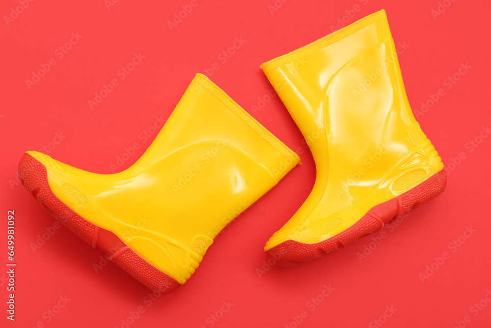 Yellow gumboots on red background