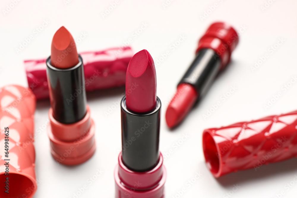 Different stylish lipsticks on light background, closeup