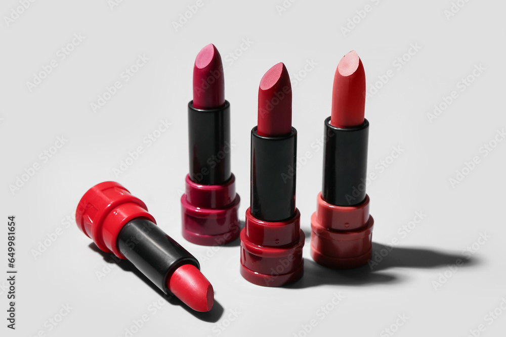 Different new stylish lipsticks on light background, closeup