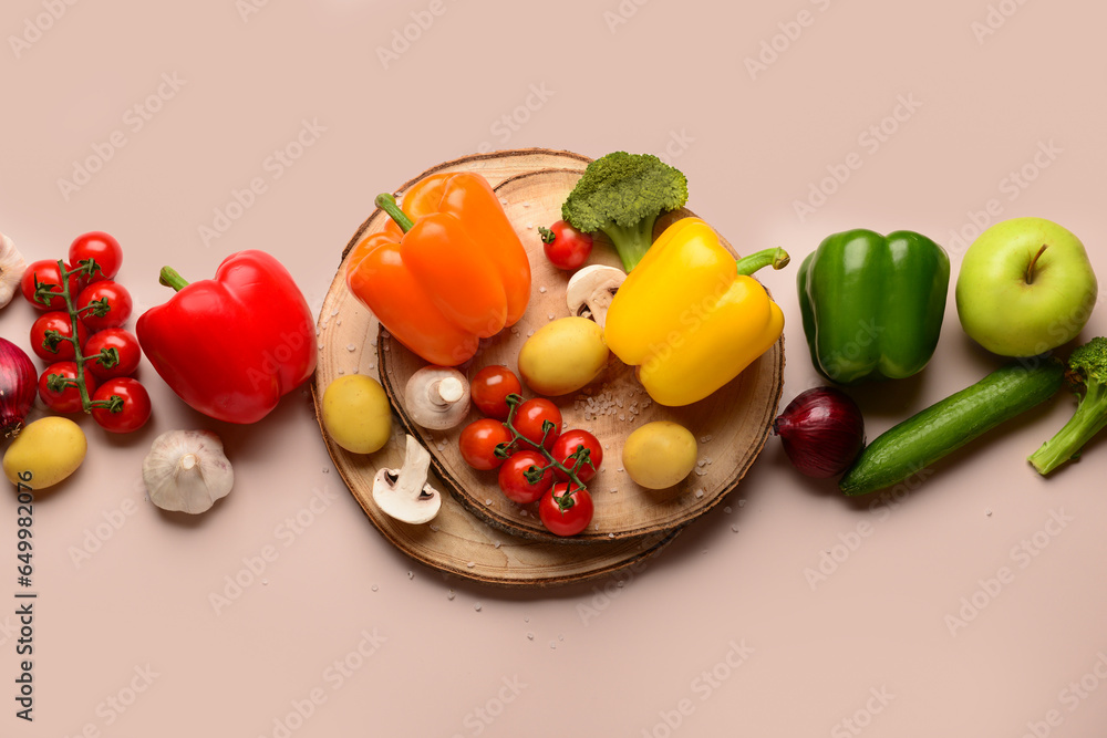 Wooden boards with different fresh vegetables on beige background