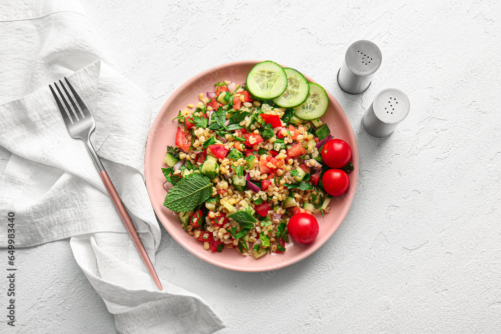 Plate with delicious tabbouleh salad on light background