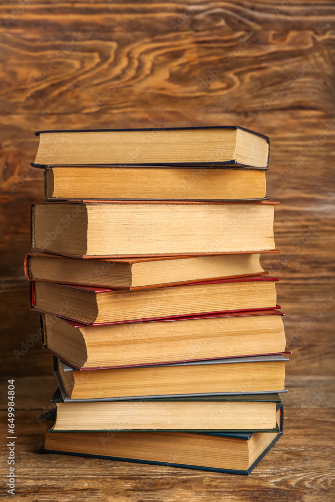 Stack of old hardcover books on wooden background