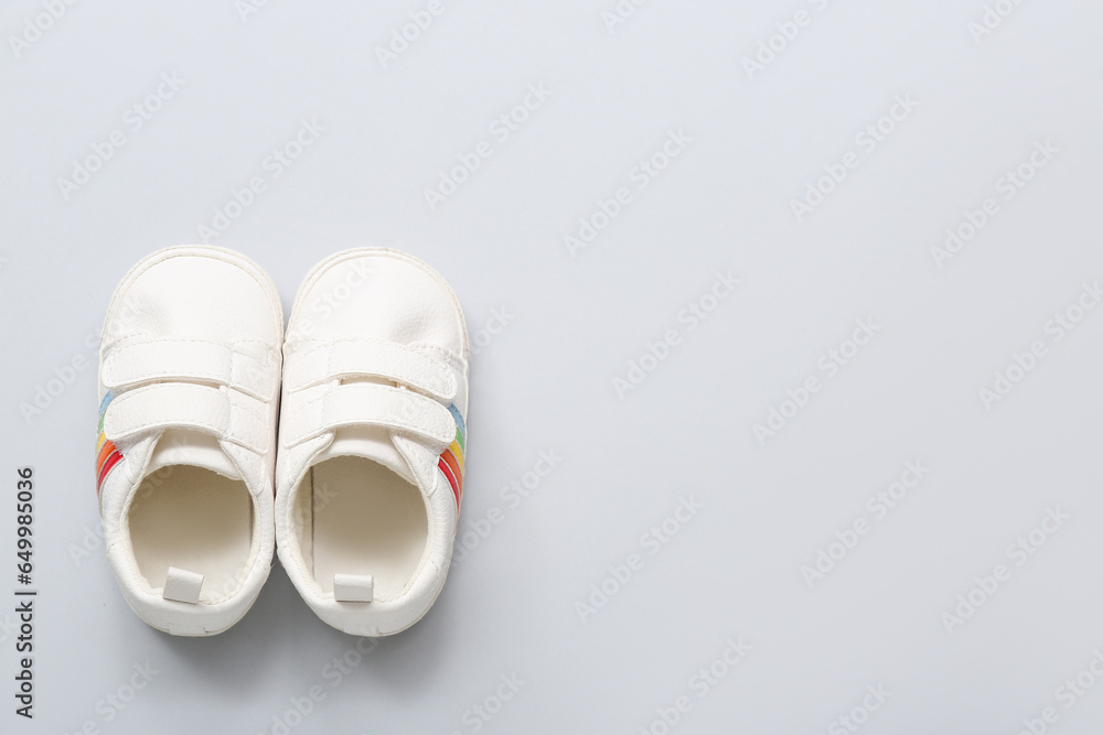 Stylish baby shoes on grey background