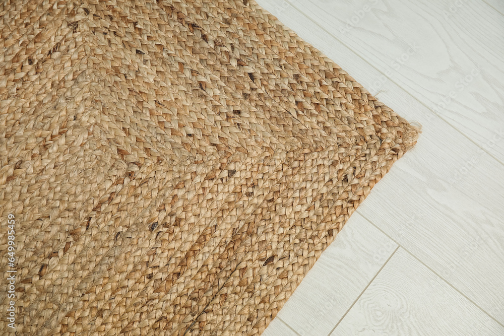 Stylish wicker rug in living room, closeup