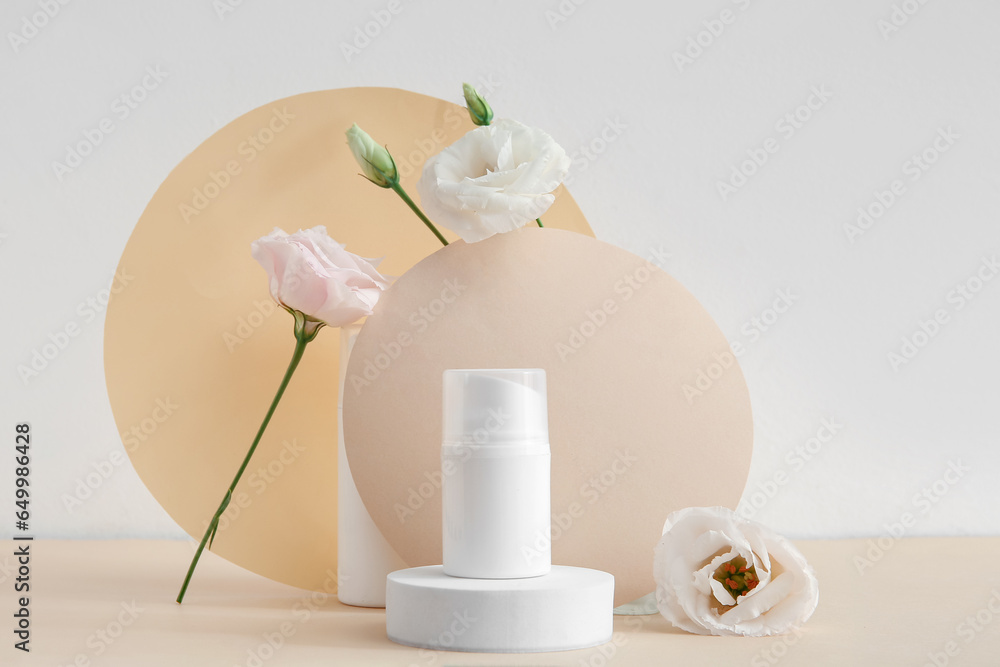 Composition with bottle of cosmetic product, plaster podium and beautiful eustoma flowers on beige background