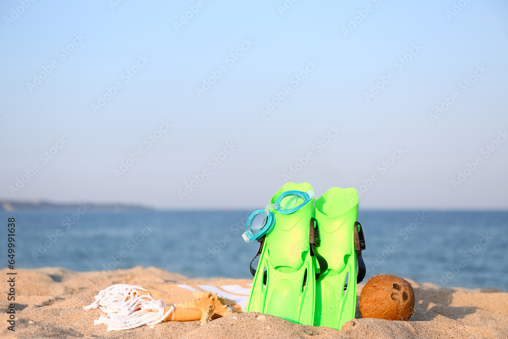 Set of beach accessories and ripe coconut on sea beach