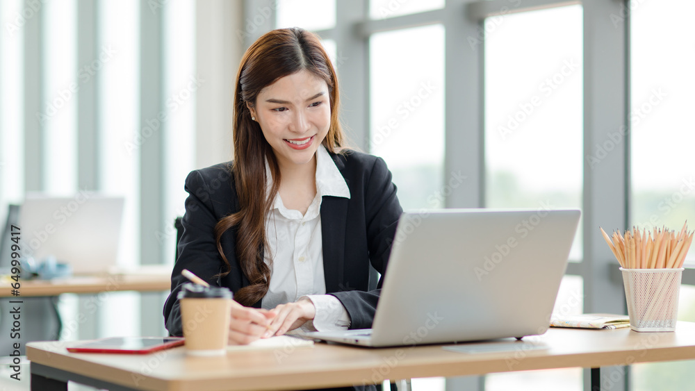 Portrait shot of Asian professional successful female businesswoman secretary employee in formal suit sitting smiling look at camera in company office