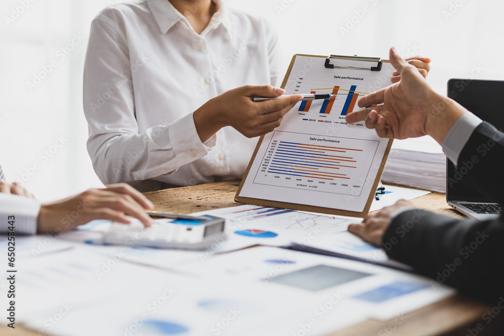 Business advisory meeting discussing analyzing company growth using business reports and financial charts. Brainstorming, analyzing strategies and planning investments.