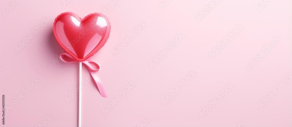 Valentine s Day card with pink heart shaped lollipop candy on pink paper background