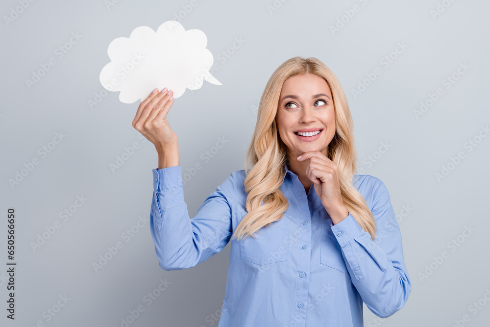 Portrait of creative minded lady hand touch chin look hold empty space cloud shape bubble card isolated on grey color background