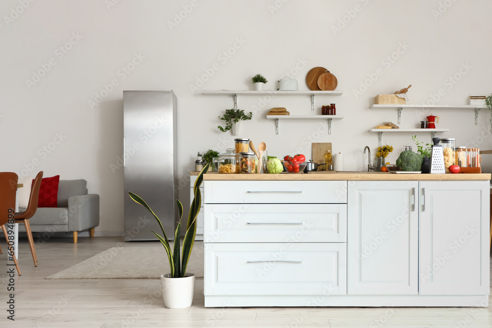 Interior of light kitchen with counters, shelves and food